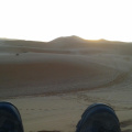 los pies de VHS y el sol al amanecer en el desierto de Sahara